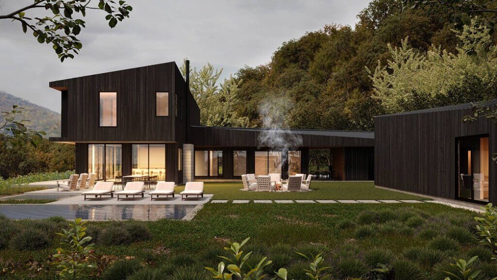 hudson valley modern mountain home rendering Una moderna casa de madera oscura con grandes ventanales está rodeada de vegetación y árboles. Hay tumbonas junto a una piscina y gente sentada alrededor de una hoguera en el césped. El humo del fuego se eleva hacia el cielo del atardecer.