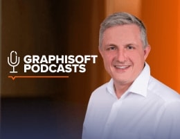 A smiling man in a white shirt stands next to the “Graphisoft Podcasts” logo on a blurred dark and orange background.