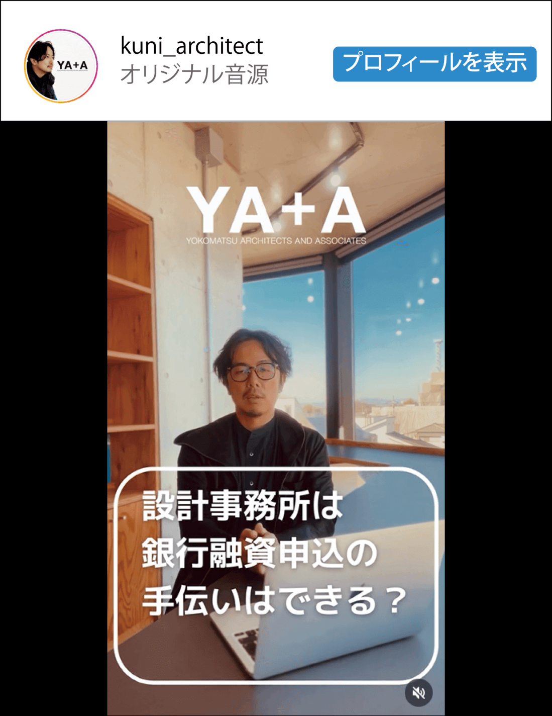 大きな窓から街の景色が見えるモダンなオフィスで、眼鏡をかけた男性がノートパソコンを持ってデスクに座っている。画像には日本語のテキストが重なり、「設計事務所は銀行融資申込の手伝いはできますか?.