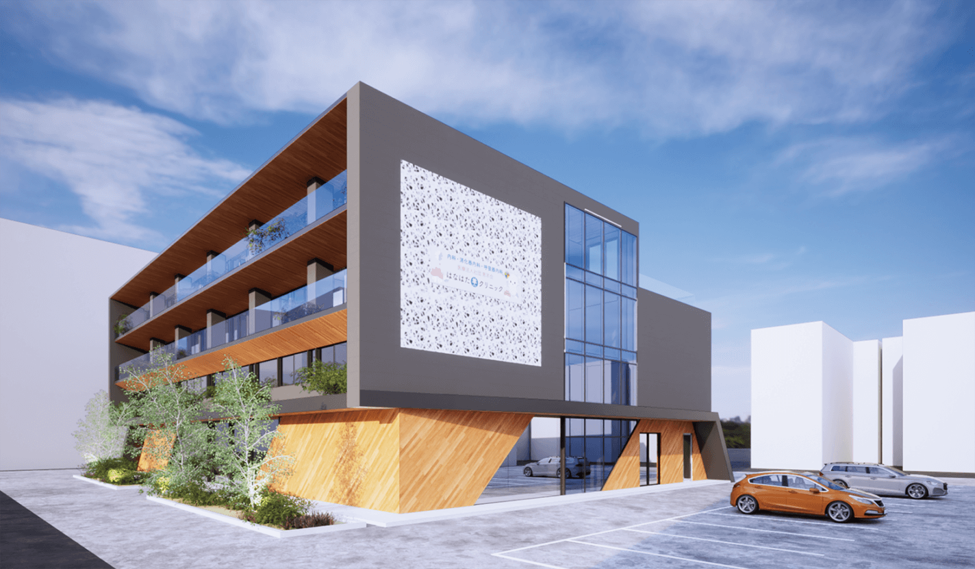 3階建てのモダンな建物で、大きな窓、木とグレーの羽目板、植栽のあるバルコニー、テラッツォ風の特徴的な壁、青空の下、前面に車が並ぶ小さな駐車場がある。.